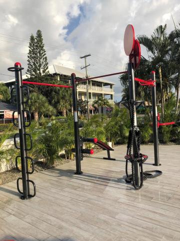 The image shows an outdoor fitness or exercise area equipped with various workout stations