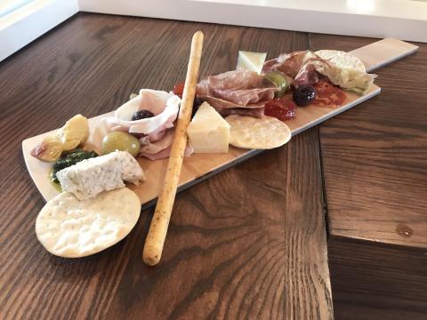The image shows a charcuterie board featuring an assortment of foods, ideal for snacking or as an appetizer