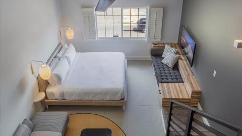 The image features a modern, minimalist bedroom