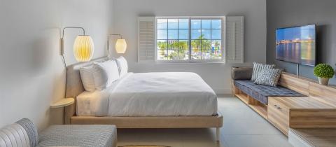 This image features a modern, well-lit bedroom