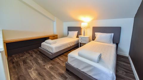 This image shows a neatly arranged bedroom with three single beds