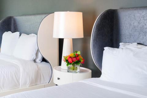 This image shows a stylish bedroom setting with two twin beds