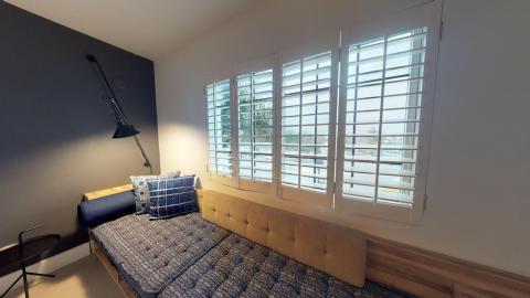 This image shows a well-lit, contemporary bedroom