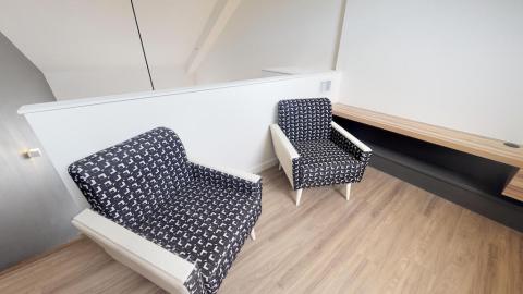 The image shows an attic room designed with a modern and minimalist aesthetic