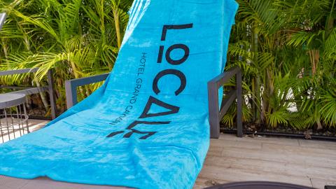 This image shows a bright turquoise towel draped over a sun lounger