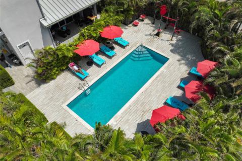 This image shows an aerial view of a pool area surrounded by lush greenery