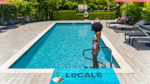 This image features an outdoor swimming pool at the Locale Hotel in Grand Cayman