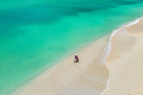 The image depicts a beautiful aerial view of a tropical beach