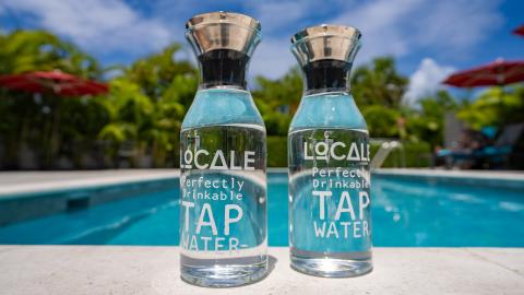The image features two glass bottles filled with water