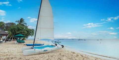 The image shows a serene beach scene with clear skies and calm seas