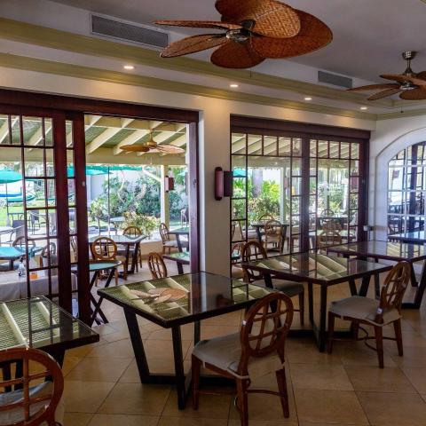 This image shows a well-appointed indoor restaurant area with a view of an outdoor pool