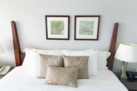This image shows a neatly made bed in a room with a simple and elegant interior