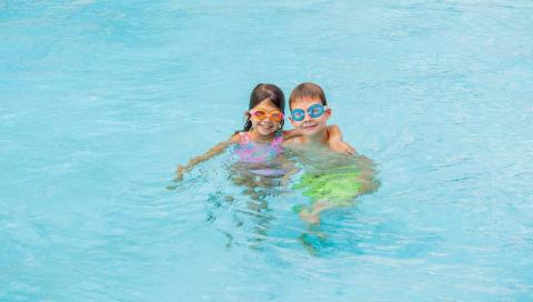 This image shows two children enjoying time in a swimming pool