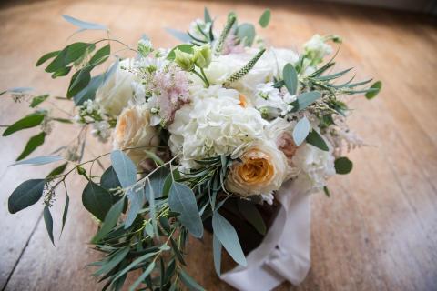 This image shows a beautiful bouquet of flowers resting on a wooden floor
