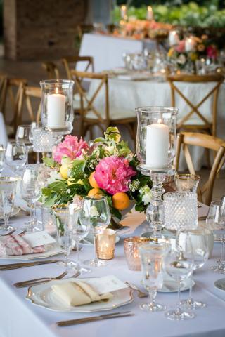 This image shows an elegantly decorated dinner table setting at an event, possibly a wedding reception or a formal banquet