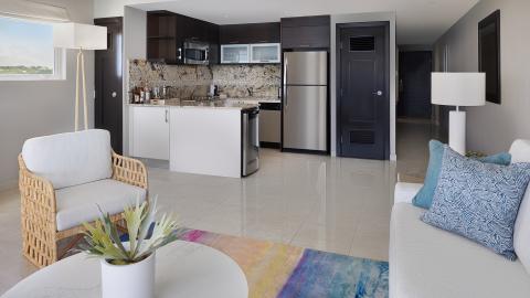 This image shows the interior of a modern apartment with a combined living and kitchen area