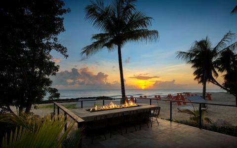 The image features a beautiful beachside setting at sunset