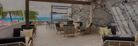 This image depicts a stylish, beachfront lounge or bar area