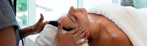 In the image, a person is receiving a facial treatment in what appears to be a spa or wellness center