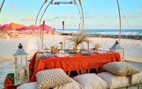 This image depicts an elegant beach dining setup