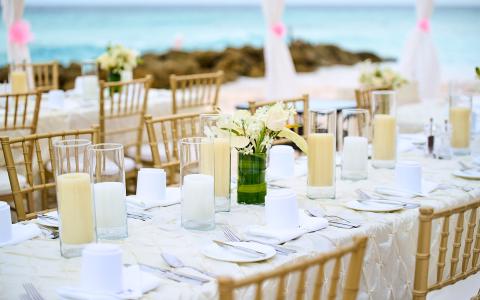 This image features an elegant outdoor dining setup by the beach