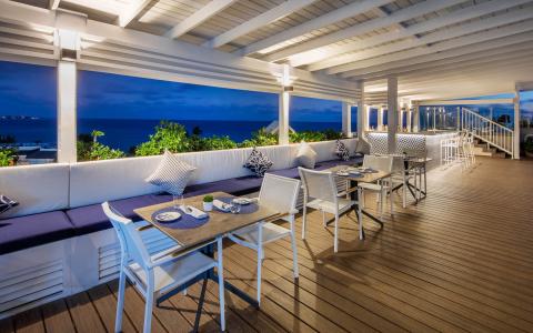 This image shows a stylish outdoor dining area at night