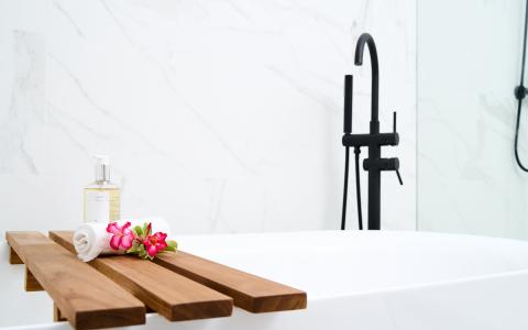 The image shows a modern bathroom setup featuring a white bathtub