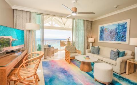 This is an image of a modern and stylish living room with a beachfront view