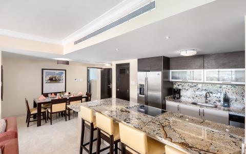 This image shows a modern, spacious kitchen that seamlessly opens into a dining area
