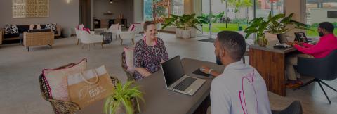The image shows a sleek, modern workspace setting probably within a hotel or a corporate business environment