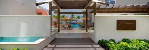 The image shows a stylish outdoor pool area at a resort or hotel