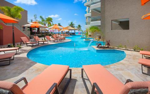 The image shows a luxurious outdoor pool area at a resort