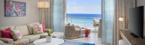 This image shows a stylish and modern seaside living area in an apartment or hotel room