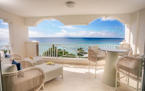 This image shows a spacious balcony with a breathtaking view of the ocean