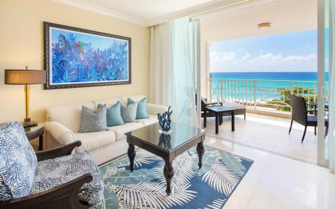 The image shows a beautifully decorated living room with a clear view of the ocean