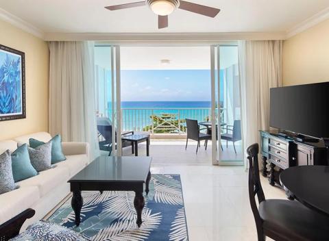 The image shows a modern beachfront apartment with a luxurious interior