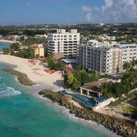 This image shows a coastal view featuring a beachfront lined with resort hotels or apartment buildings