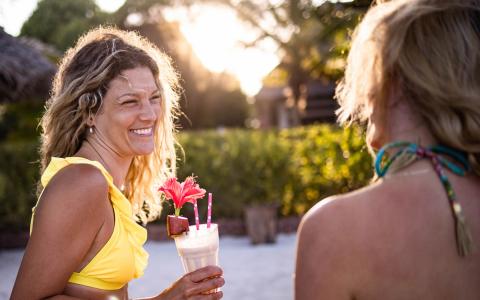 The image shows two women enjoying a cheerful moment together outdoors