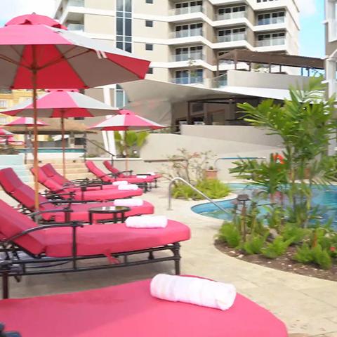 The image shows a luxurious poolside setting