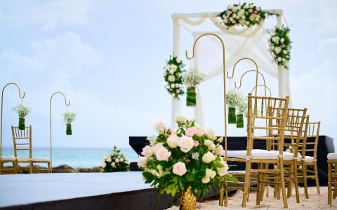 This image shows an outdoor wedding setup on a sandy beach