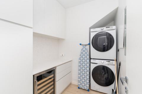 Modern compact laundry room with stacked washing machines and dryer