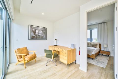 Modern home office with wooden desk and green chair