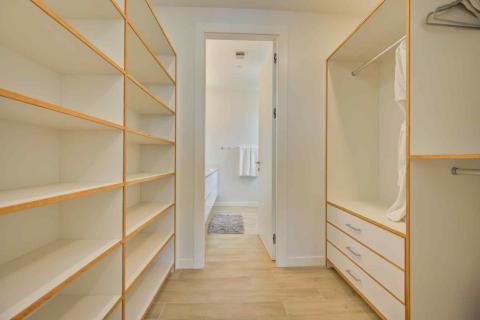 One Canal Point: Well-organized walk-in closet with open shelving and light wood flooring