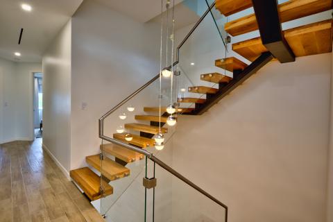 Modern staircase with floating wooden steps and glass panels