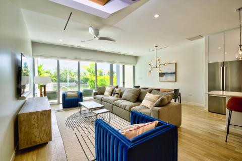  Alt Tag: Modern living room with large windows opening to patio and greenery