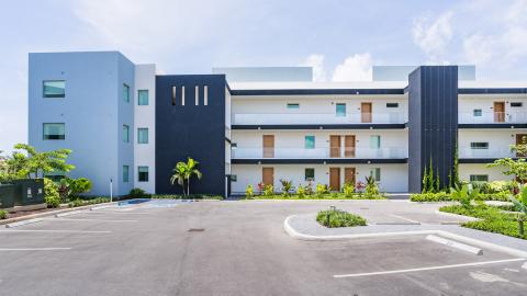 Modern apartment complex with balconies and tropical landscaping