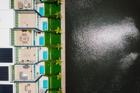 The image shows an aerial view of a row of waterfront houses