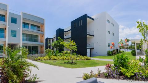One Canal Point: Modern residential complex with cubic architecture, tropical garden, and water view