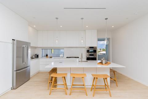 Modern kitchen with island, white cabinetry, and stainless steel appliances