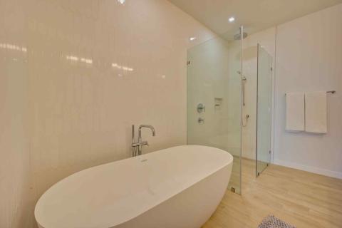 One Canal Point: Modern bathroom with freestanding bathtub, walk-in shower, and hexagonal tile walls
